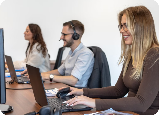 three people as customer services reps with headsets typing on laptop