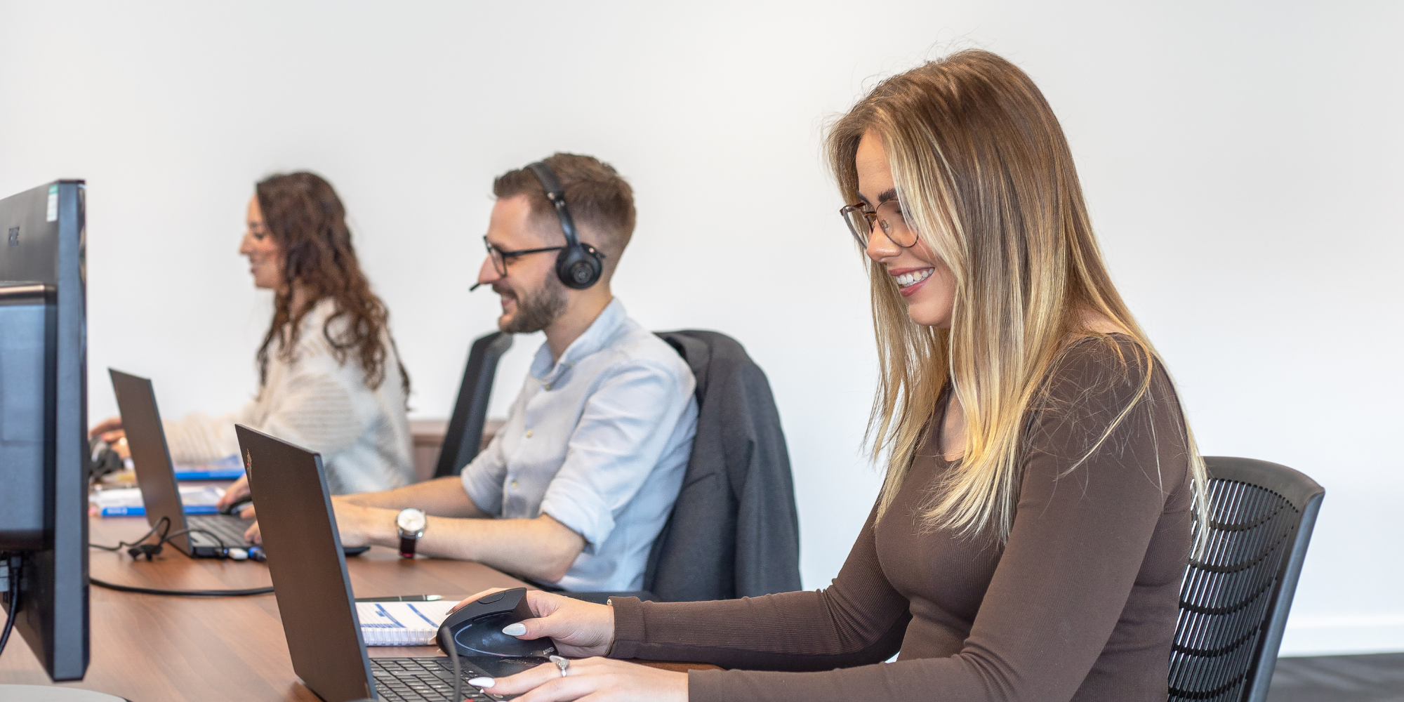 brymec team members on the phones and computers, smiling