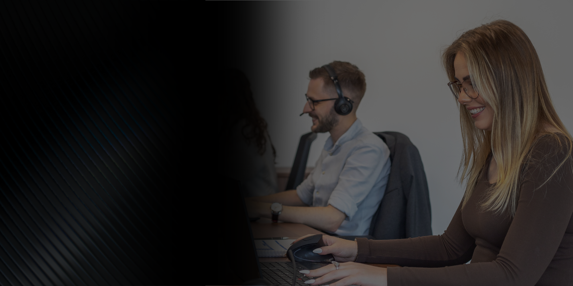 three brymec team members sat at a desk working on laptops